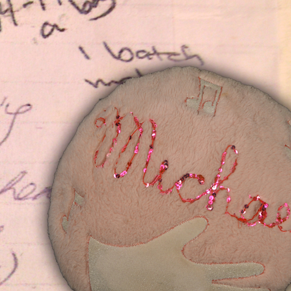A fuzzy handmade ornament displaying a handprint and the name Michael